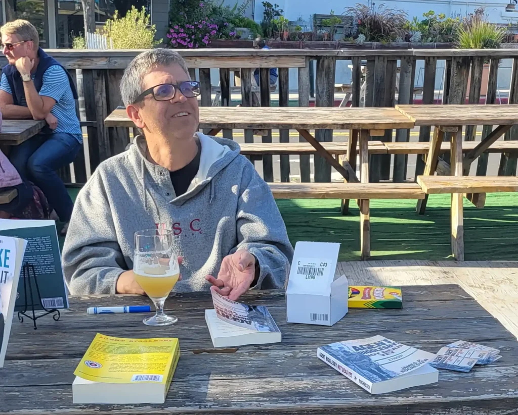 Author sitting with book at book signing